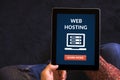 Hands holding tablet with web hosting concept on screen
