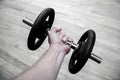 Hands holding tight a gym bar with iron weights