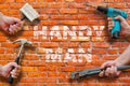 Hands holding tools on brickwall background with handyman text on it Royalty Free Stock Photo