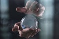 Hands holding a transparent crystal glass ball on a black background Royalty Free Stock Photo