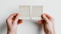 Hands Holding Two Empty Instant Film Frames Against a Plain Background, Ready for New Memories in a Creative Moment Royalty Free Stock Photo