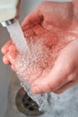 Hands holding water with bubbles while washing