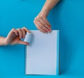 Hands holding white bottle for pills and notebook on a blue background Royalty Free Stock Photo