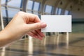 Hands holding a white business visit id card, gift, ticket, pass, present showing close up on blurred blue background Royalty Free Stock Photo