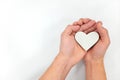 Hands holding a white heart in white background. Kindness and pure love concept. Royalty Free Stock Photo