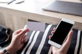 Hands holding white mobile phone with blank black desktop screen and a white empty business card Royalty Free Stock Photo