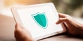 Hands holding a white tablet showing a shield icon, symbolizing internet security, privacy, and antivirus protection for devices Royalty Free Stock Photo