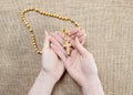Hands holding wooden brown rosary Royalty Free Stock Photo