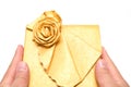 Hands holding a wrapped golden present box on white