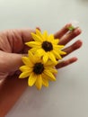 Hands holding yellow flower with chold holding white flower