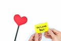 Hands holding a yellow welcome back note card with a red heart. Back to work, office and school concept. Royalty Free Stock Photo