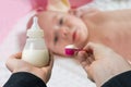 Hands holds bottle with milk formula prepaired for feeding baby
