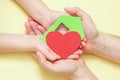 Hands holds green paper house with red heart Royalty Free Stock Photo