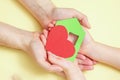 Hands holds green paper house with red heart Royalty Free Stock Photo