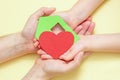 Hands holds green paper house with red heart Royalty Free Stock Photo