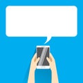 Hands holing white smartphone with blank speech bubble for text.