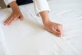 Hands of hotel maid making bed