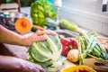 The hands of the housewife prepare to cut the cauliflower. Lots of fresh vegetables around. Eat healthy to stay in shape Royalty Free Stock Photo