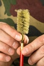 Hands of hunter attach a nylon brush to the cleaning rod
