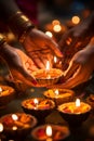 Hands ignite the traditional Diwali oil lamps, marking the start of a spiritual celebration