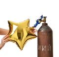Hands inflate gold star balloon use Helium Tank with Economy Regulator Fill Valve Royalty Free Stock Photo