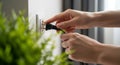 Hands inserting black electrical plug into white wall outlet Royalty Free Stock Photo