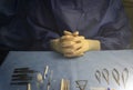hands of an instrumentalist nurse prepared on a blue sterile field and surgical material for an ophthalmologic retinal surgery