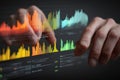 Hands interacting with colorful digital financial charts and data on a transparent screen in a dark setting Royalty Free Stock Photo
