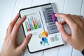 Hands interacting with digital device displaying financial charts and graphs Royalty Free Stock Photo