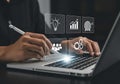 Person using stylus on laptop with technology icons light bulb graph team gears target computer hand Royalty Free Stock Photo