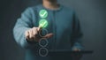 Hands interacting with a vertical glowing checklist of green circle check marks on a digital tablet (concept Royalty Free Stock Photo