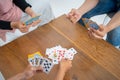 Hands issuing cards to table while playing cards together