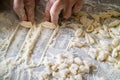 Hands of Italian woman making traditional fresh pasta on a marble table