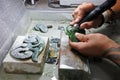 Hands of a Jade ornamental green rock carver at work Royalty Free Stock Photo