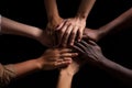 Hands joined in a gesture of collaboration, teamwork among different ethnicities.