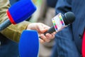 the hands of journalists hold microphones for an interview