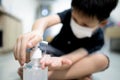 Hands of kid boy with alcohol antiseptic gel,wash hands with hand sanitizer,kill germs,bacteria,viruses,asian child wearing face