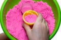 Hands of a kid playing with pink magic sand Royalty Free Stock Photo