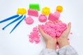 Hands of a kid playing with pink magic sand Royalty Free Stock Photo