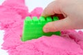 Hands of a kid playing with pink magic sand Royalty Free Stock Photo