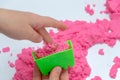 Hands of a kid playing with pink magic sand Royalty Free Stock Photo