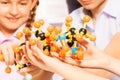 Hands of kids assembling molecule model at lab Royalty Free Stock Photo