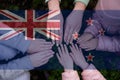 Hands of kids on background of New Zealand flag. New Zealander patriotism and unity concept