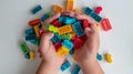 The Hands of the kids hold colorful toy bricks and blocks for building toys on a white background. Generative AI Royalty Free Stock Photo