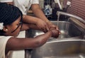 Hands, kitchen sink and mom with kid, teaching or help to wash with soap, water or clean to stop germs. African family Royalty Free Stock Photo