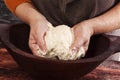 Hands knead dough.