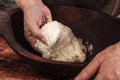 Hands knead dough.