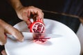 Hands with a knife cut pomegranate on a white plate