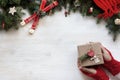 Hands in knitted gloves holding a gift. Pine branches with Christmas decor