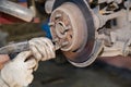 Hands knock off the thread on the bolt of the worn rear hub with a hammer. Royalty Free Stock Photo